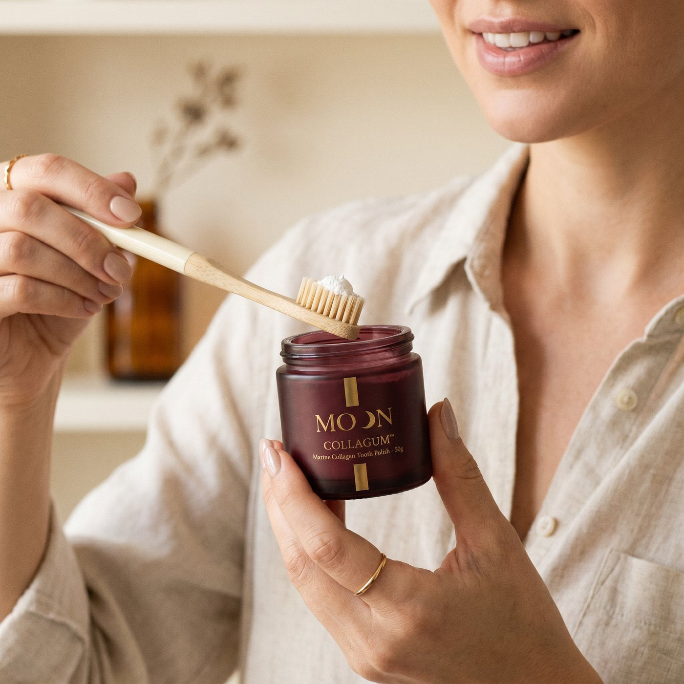 A smiling woman putting CollaGum on her toothbrush