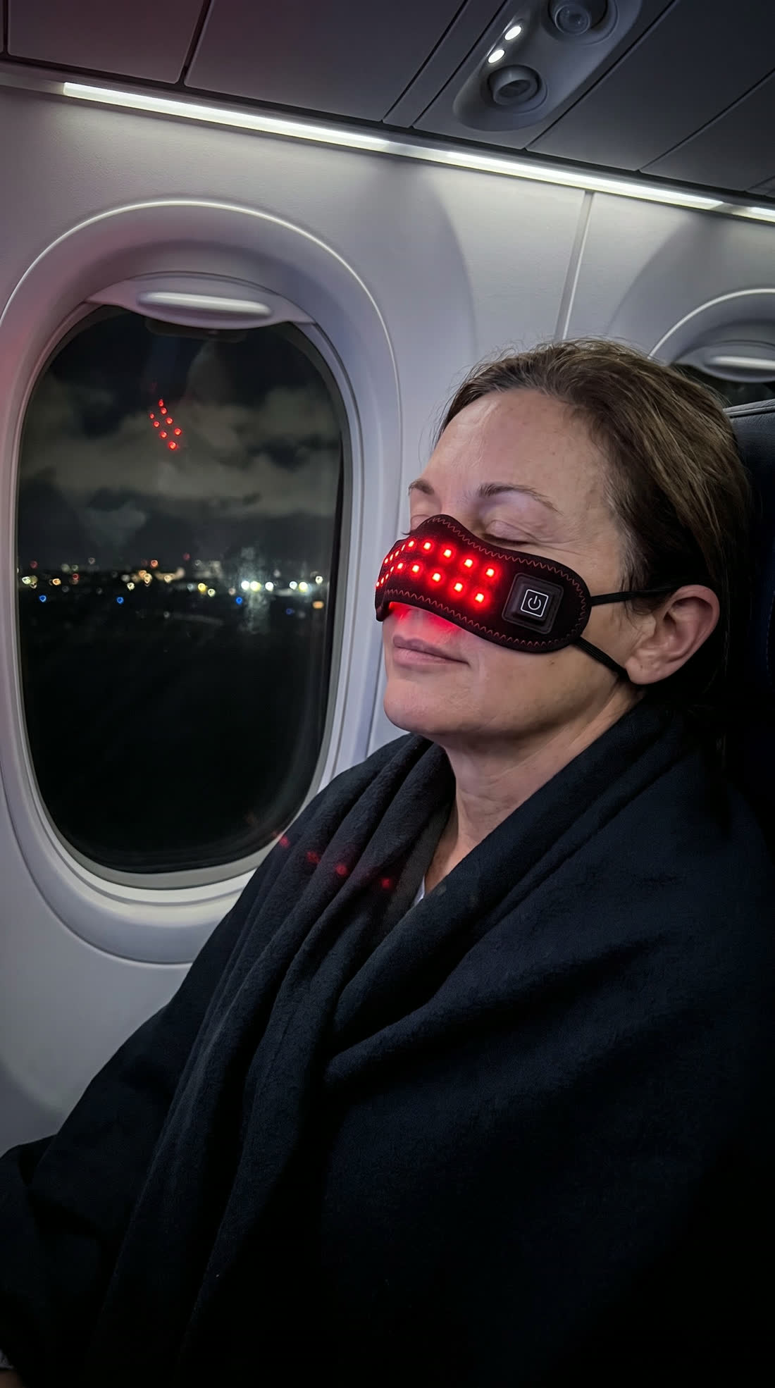 Woman on a night flight wearing the sinus band