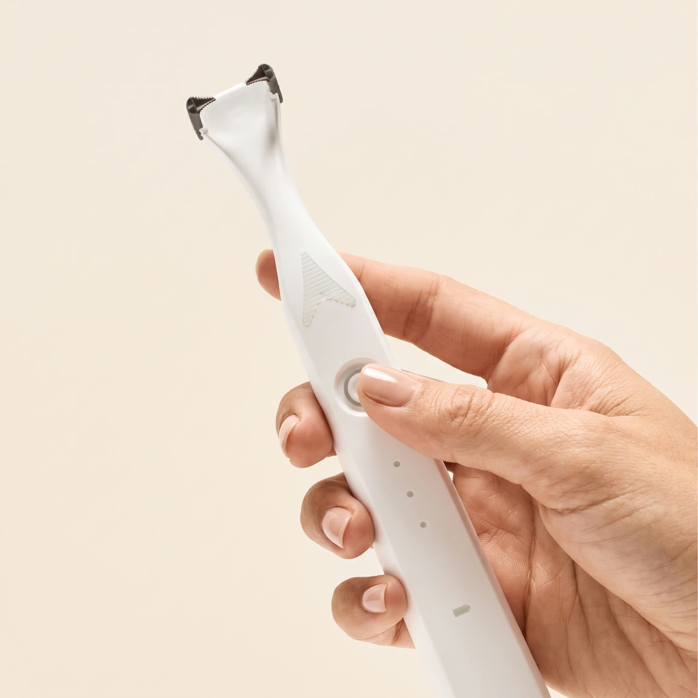 A hand pressing the button of the flosser