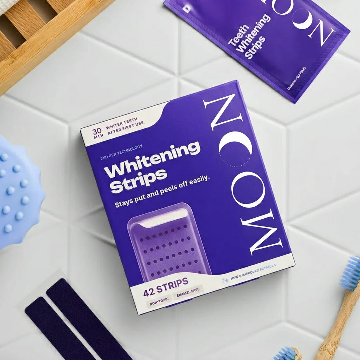 A box of MOON purple whitening strips on bathroom tiles